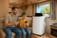 Father and son enjoying air conditioner in a caravan