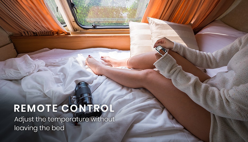 Person sitting on a bed in a vehicle with a remote control, wearing a smartwatch.