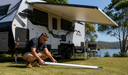 Man attaching support leg to caravan awning