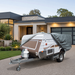 Camper trailer with heavy duty cover parked in driveway