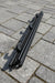 Black aluminium rod on a paved surface