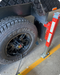 Tire on a vehicle with a red jack attached.