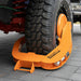 Orange wheel clamp on a vehicle tire on a paved surface