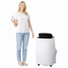 Woman holding a remote control next to a white portable air conditioner 7000 BTU 