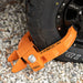 Orange security lock on a car tire on a gravel surface