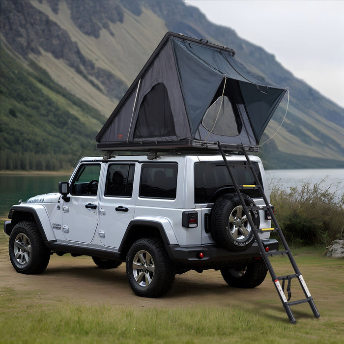 White Jeep Wrangler with a rooftop tent in a mountainous landscape